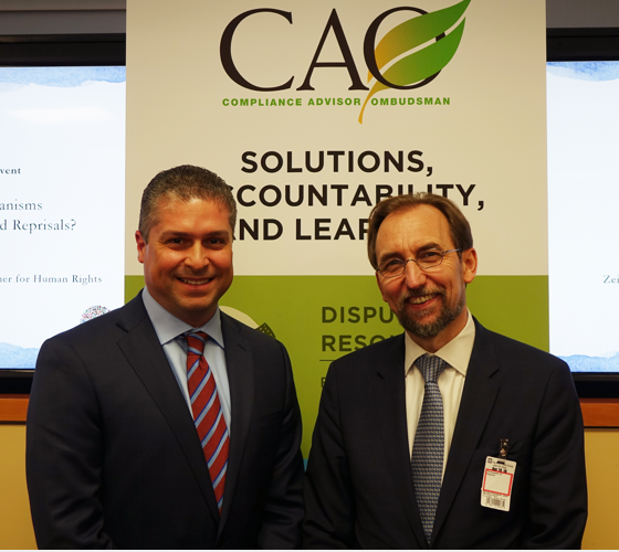 Men pausing in front of a CAO banner